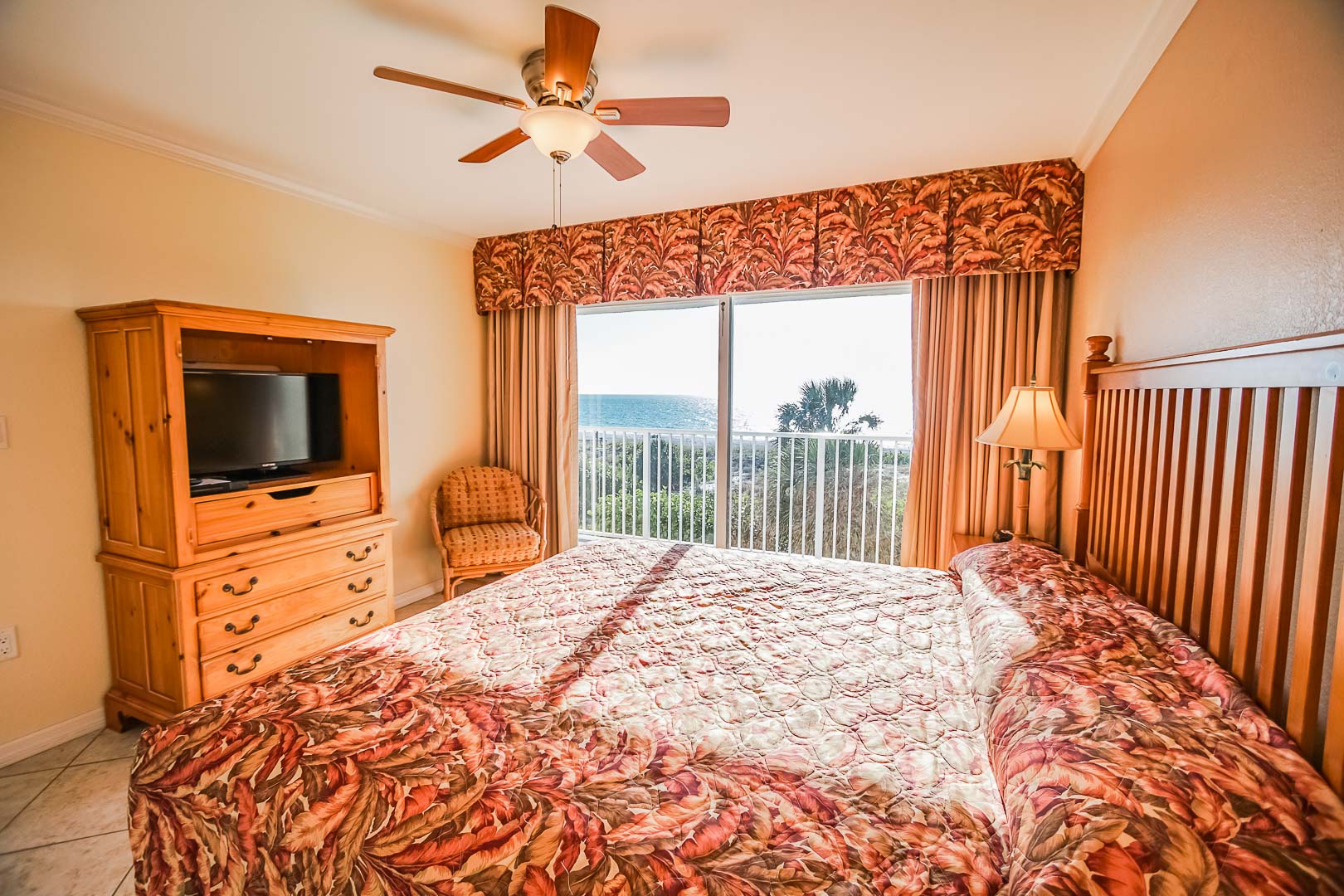 A vibrant bedroom with a balcony view at VRI's Sand Pebble Resort in Treasure Island, Florida.